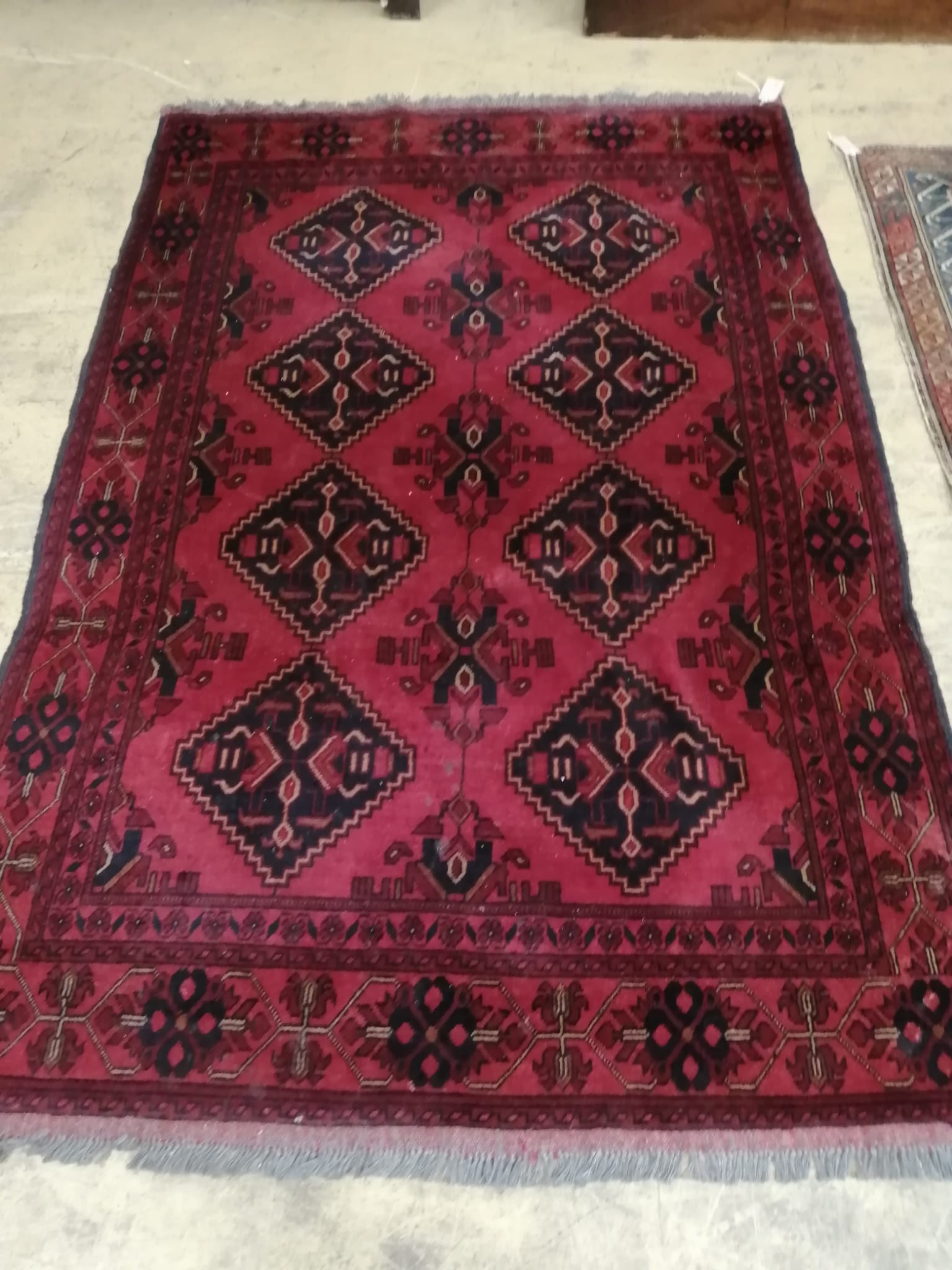 An Afghan red ground rug, 190 x 128cm